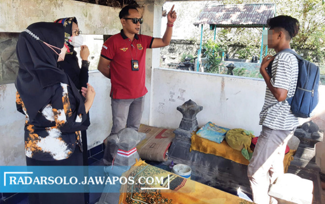 PINDAH: Tim Satpol PP Boyolali membantu anak sebatang kara yang sudah dua bulan tinggal di samping makam ayahnya di pemakaman umum Klaseman, Gatak, Kabupaten Sukoharjo. (RAGIL LISTIYO/RADAR SOLO)