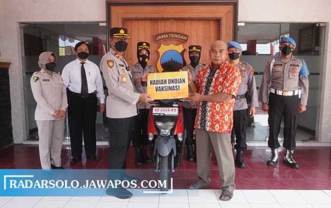 BERKAH VAKSINASI: Wakapolres Sukoharjo Kompol Teguh Prasetyo serahkan hadih sepeda motor kepada Parto Suwarno di Mako Polres Sukoharjo, Senin (29/8). (IWAN KAWUL/RADAR SOLO)