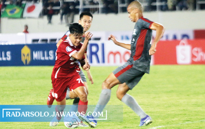 TALENTA MUDA: Gelandang lincah Persis Solo Zanadin Fariz (kiri) berduel dengan pemain Madura United dalan lanjutan Liga 1 di Stadion Manahan, Selasa (23/8). (M. IHSAN/RADAR SOLO)