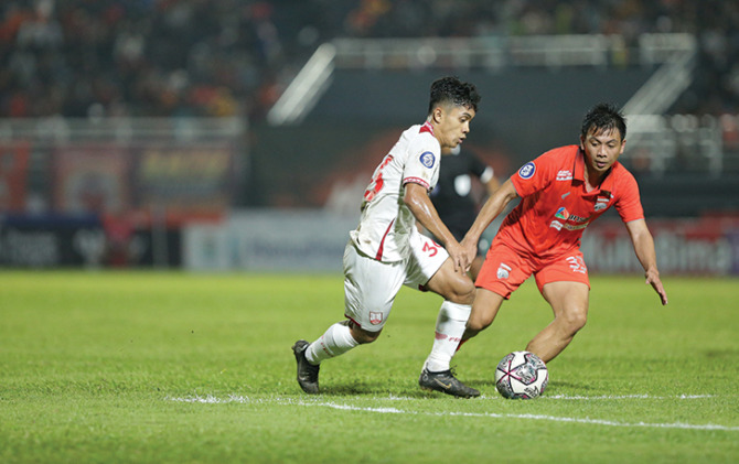 YOUNG GUNS: Winger muda Persis Solo Althaf Indie (kiri) dikawal pemain Borneo FC Wahyudi Setiawan Hamisi, dalam lanjutan Liga 1 di Stadion Segiri Samarinda, Minggu malam (28/8). (ISTIMEWA)