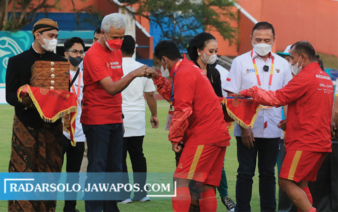 APRESIASI: Gubernur Jateng Ganjar Pranowo dan Ketum PSSI Mochamad Iriawan mengalungkan medali perak ke pemain timnas Indonesia cabor Sepakbola CP. (ARIEF BUDIMAN/RADAR SOLO)