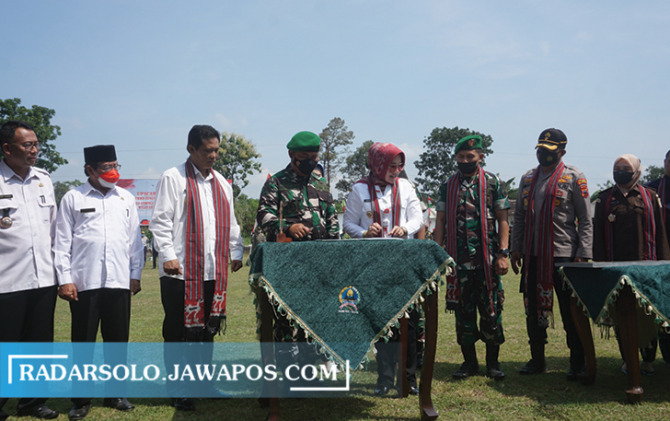 SINERGI: Kasdim 0723/Klaten Mayor Czi Paulus Caesario Prasetyo dan Bupati Klaten Sri Mulyani menandatangani hasil TMMD Sengkuyung Tahap II 2022 dan KBMKB ke-XIII di Lapangan Desa Gedongjetis, Tulung, Rabu (24/8). (ANGGA PURENDA/RADAR SOLO)