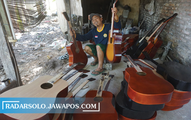 TERUS BERTAHAN: Salah satu perajin gitar di Desa Bener, Kecamatan Wonosari sedang memperlihatkan produksi gitarnya. (ANGGA PURENDA/RADAR SOLO)