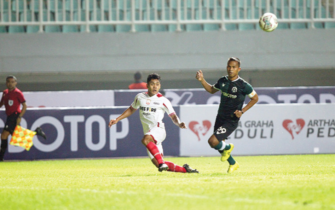 BINTANG MASA DEPAN: Pemain muda Persis Solo Althaf Indie mengirim umpan, melewati hadangan penggawa Persikabo 1973 Manahati Lestusen di Stadion Pakansari, tadi malam. (ISTIMEWA)