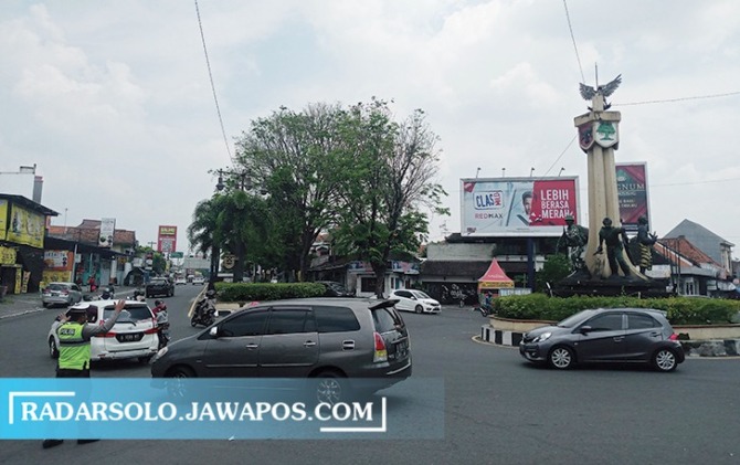 JALUR SIBUK: Anggota Satlantas Polres Sukoharjo atur lalu lintas di Tugu Kartasura belum lama ini. (IWAN KAWUL/RADAR SOLO)