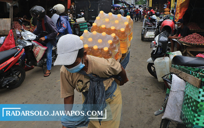 Buruh gendong di pasar tradisional Kota Solo membawa minyak goreng kemasan belum lama ini. (ARIEF BUDIMAN/RADAR SOLO)
