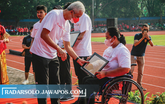 BERI APRESIASI: Gubernur Jawa Tengah Ganjar Pranowo menyerahkan penghargaan kepada atlet NPC berprestasi dalam peringatan Haornas di Stadion Sriwedari, Jumat (9/9). (M. IHSAN/RADAR SOLO)