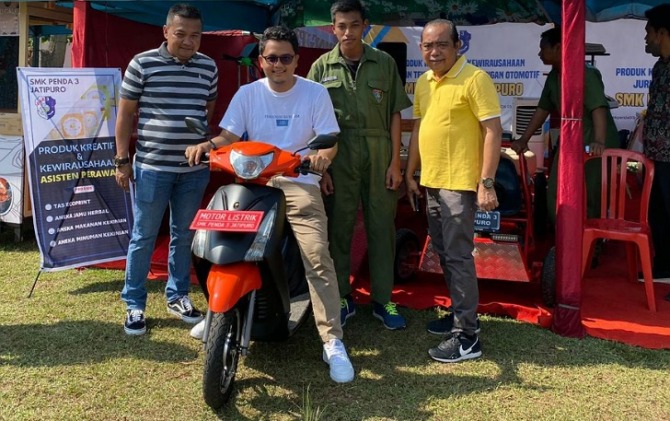 Ilyas Akbar Almadhani, ketua Forum Karang Taruna Karanganyar saat mencoba sepeda listrik modifikasi siswa SMK Penda 3 Jatipuro. (RUDI H/RADAR SOLO)
