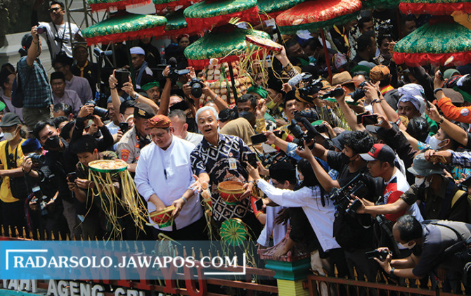 KEMBALI BERGELIAT: Menko Perekonomian Airlangga Hartarto dan Gubernur Ganjar Pranowo ikut menyebar apem di tradisi Yaa Qowiyyu Jatinom, Klaten, Jumat (16/9). (ARIEF BUDIMAN/RADAR SOLO)