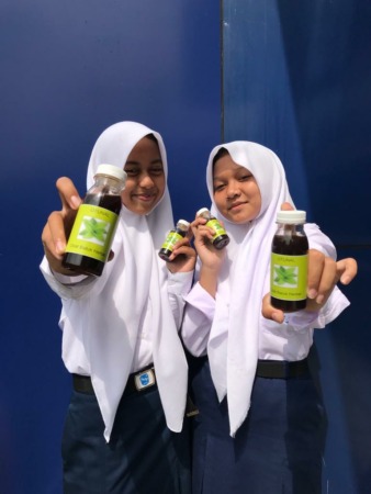 ALAMI: Cheryl Elsa Lutfiyah Damayanti dan Dinda Alya Ramadhani perlihatkan obat batuk sirup Otunal dari ekstrak daun sirsak. (SMPN 20 SURAKARTA FOR RASO)