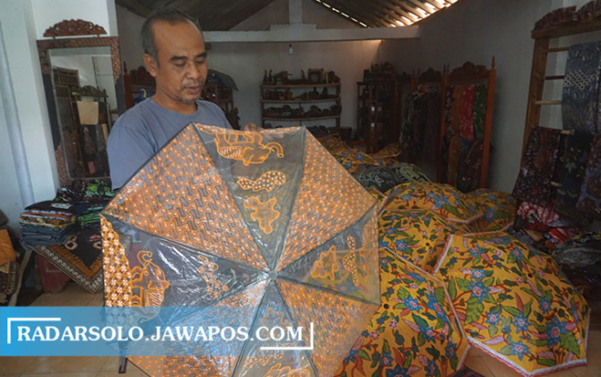 TAK MENYERAH: Sularto alias Jeprik memperlihatkan payung batik yang diproduksinya di Desa Jarum, Kecamatan Bayat, Klaten, kemarin. (ANGGA PURENDA/RADAR SOLO)