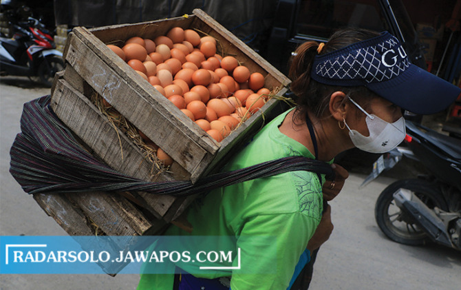 BAHAN PANGAN: Pekerja memanggul tumpukan telur di pasar tradisional belum lama ini. Harga komoditas tersebut kerap fluktuatif. (ARIEF BUDIMAN/RADAR SOLO)