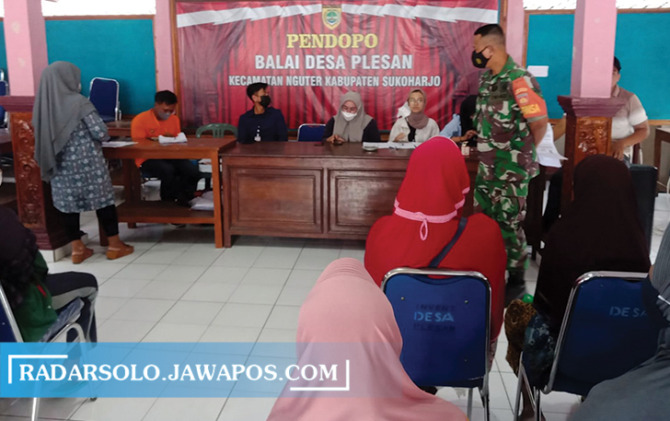 TERTIB: Warga Desa Plesan, Kecamatan Nguter antre mendapatkan BLT BBM balai desa setempat, Minggu (11/9). (IWAN KAWUL/RADAR SOLO)