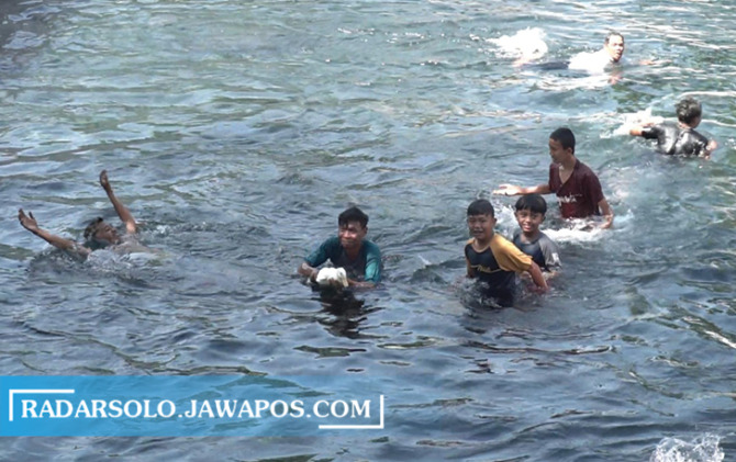 MERIAH: Pengunjung Umbul Tlatar Boyolali memperebutkan bebek putih dalam peringatan Tradisi Lametan, Sabtu (17/9).  (RAGIL LISTIYO/RADAR SOLO)