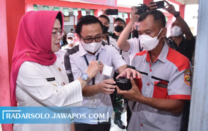 UJI COBA: Bupati Sukoharjo Etik Suryani mencoba e-Retribusi di Pasar Kepuh, Kecamatan Nguter, Rabu (26/10). (IWAN KAWUL/RADAR SOLO)