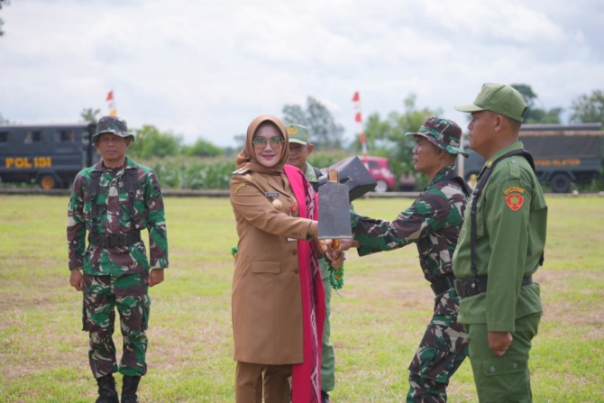 SIMBOLIS: Bupati Klaten Sri Mulyani menyerahkan pacul kepada personel TNI dan linmas di Lapangan Desa Wonosari, Kecamatan Trucuk, Senin (24/10). (DOKUMENTASI DISKOMINFO KLATEN FOR RADAR SOLO)