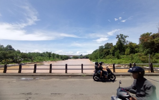 Warga melintas di jembatan, tak jauh dari pintu air Waduk Gajah Mungkur, Sabtu (22/10). (IWAN ADI L/RADAR SOLO)