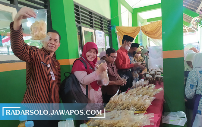 UNIK: Kepala SMAN 1 Nogosari Tutur Aris Kusmanto (kiri) memperlihatkan salah satu produk yang dipamerkan dalam gelar karya kewirausahaan di sekolah setempat, kemarin (13/10). (BRYAN PUTRA PRANANDA/RADAR SOLO)