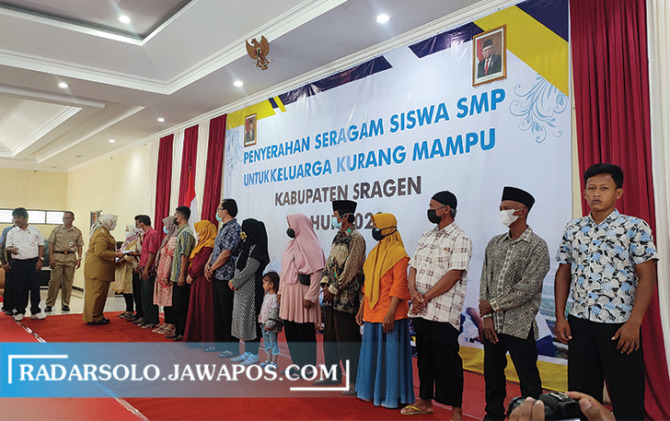 BERI MANFAAT: Penyerahan simbolis pemberian seragam sekolah di Gedung Kartini Sragen, kemarin. (AHMAD KHAIRUDIN/RADAR SOLO)