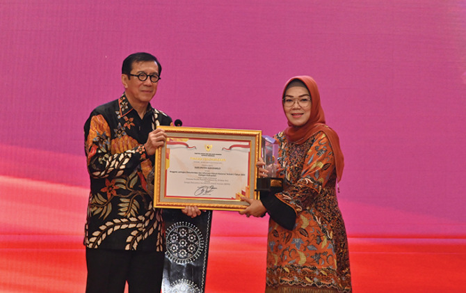 BERTURUT-TURUT: Bupati Sukoharjo Etik Suryani (kanan) menerima penghargaan JDIH nasional terbaik II dari Menteri Hukum dan HAM RI Yasona H Laoly, Selasa (18/10). (BAGIAN HUKUM SETDA KABUPATEN SUKOHARJO FOR RADAR SOLO)