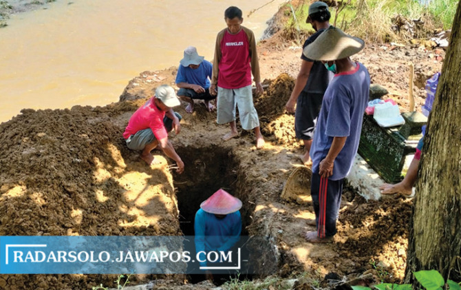 SWADAYA: Warga memindahkan makam di TPU Gedhe, Desa Banyakprodo, Tirtomoyo, Wonogiri, Minggu (23/10). (IWAN ADI LUHUNG/RADAR SOLO)