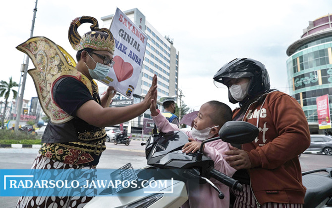 BERI EDUKASI: Aktivis Danar Widanarko mengajak masyarakat agar menyayangi ginjalnya di simpang empat The Park Solo Baru, Selasa (25/10). (ARIEF BUDIMAN/RADAR SOLO)