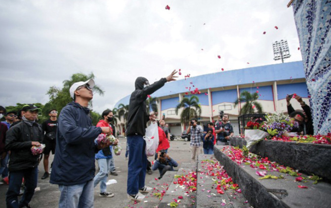 Suporter Arema menaburkan bunga di Patung Singa, Stadion Kanjuruhan, Malang. (Alfian Rizal/JawaPos)