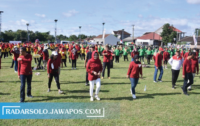 MEMBAUR: Bupati Sukoharjo Etik Suryani (tengah) senam bersama warga di Lapangan Jatisobo, Polokarto, kemarin. (IWAN KAWUL/RADAR SOLO)
