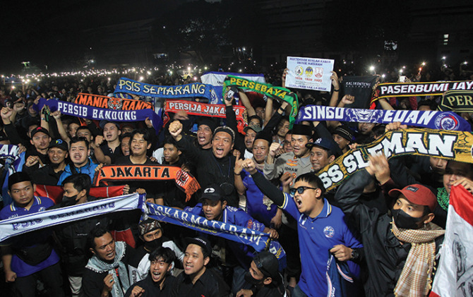 TANPA BATAS: Suporter Persis Solo, PSS Sleman PSIM Jogjakarta, PSIS Semarang dan lainya berdoa bersama di Stadion Mandala Krida untuk korban insiden Kanjuruhan, Selasa malam (4/10). (GUNTUR AGA/JAWA POS RADAR JOGJA)