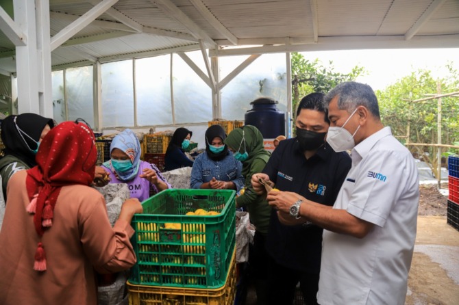 Menteri BUMN Erick Thohir mengamati produk UMKM binaan BRI yang terus berkembang.
