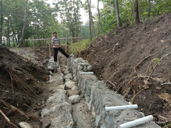 BUTUH KEJELASAN: Warga berdiri di atas proyek saluran drainase RSUD Sukowati Tangen yang melintas di lahan milik Perhutani di Desa Katelan, Jumat (4/11). (AHMAD KHAIRUDIN/RADAR SOLO)