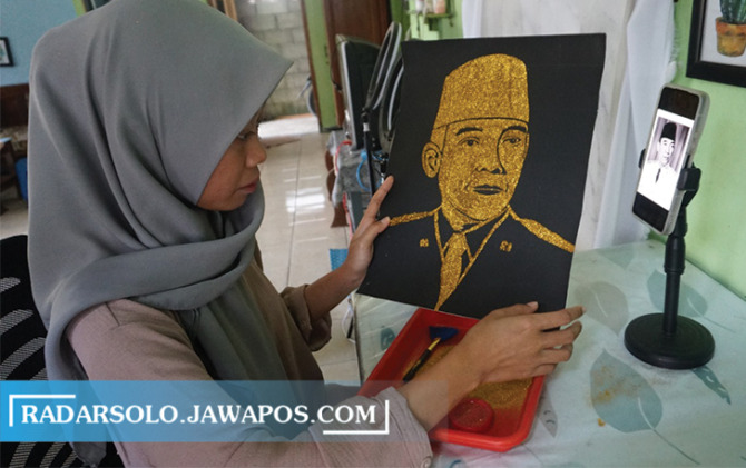 KREATIF: Erine Anisa saat menyelesaikan lukisan glitter bergambar presiden pertama Indonesia Ir Soekarno di kediamannya di Kemiri, Mojosongo, Boyolali, kemarin. (RAGIL LISTYO/RADAR SOLO)