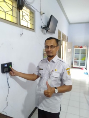TEKNOLOGI: Kades Sumberejo Tri Haryanto menjajal fingerprint di kantor desa setempat, kemarin (4/11). (PEMDES SUMBEREJO FOR RASO)