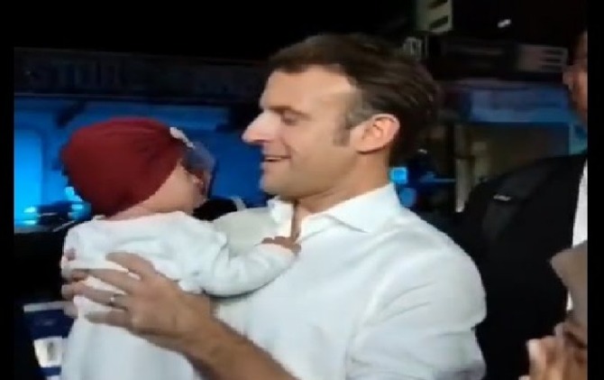 Presiden Prancis Emmanuel Macron yang menggendong bayi saat berjalan kaki usai gala dinner KTT G20 di GWK, Badung, Bali, Selasa (15/11) malam. (Istimewa)
