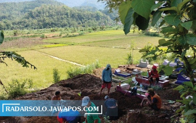HATI-HATI: Pemindahan makam di TPU Gedhe, Tirtomoyo, beberapa waktu lalu. Total sudah ada 47 makam yang dipindah. (IWAN ADI LUHUNG/RADAR SOLO)