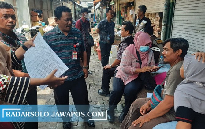 JEMPUT BOLA: Tim Diskumindag Sragen menagih retribusi ke sejumlah pedagang pasar tradisional, Selasa (22/11). (AHMAD KHAIRUDIN/RADAR SOLO)