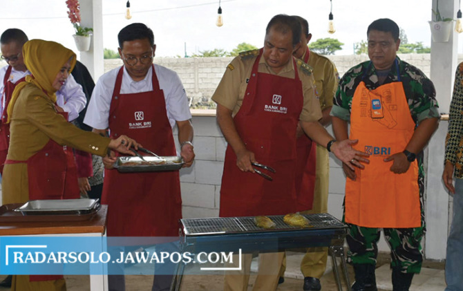 PERBAIKI GIZI: Bupati Juliyatmono mencoba mencicipi menu ikan di kampung ikan, Kelurahan Lalung, Karanganyar. (RUDI HARTONO/RADAR SOLO)