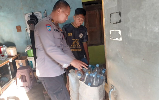 Jajaran Polsek Karangpandan mengamankan puluhan botol miras jenis ciu saat operasi pekat, Kamis (3/11) malam. (RUDI H/RADAR SOLO)