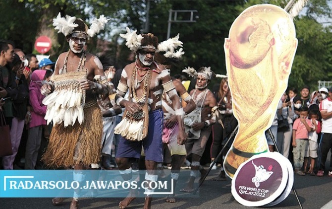 UNIK: Menyemarakkan gelaran Piala Dunia 2022 di Qatar, Suku Asmat menari di CFD Jalan Slamet Riyadi, Surakarta, Minggu (20/11). (ARIEF BUDIMAN/RADAR SOLO)