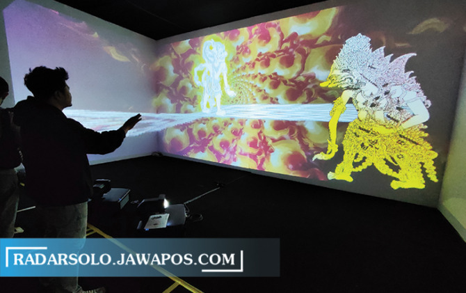 Seorang pengunjung The Park Mall Solo Baru tengah menjadi dalang dalam event Wayang In Metaverse, Rabu (2/11). Melalui teknologi bernama real time interactive media ini pengunjung bisa memainkan wayang layaknya dalang hanya dengan menggerakkan tangan saja