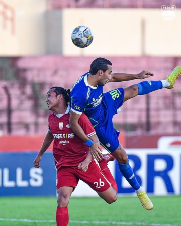 DUEL UDARA: Perebutan bola antara bek Persis Solo Rian Miziar (jersey merah) dengan striker Persib Bandung Ezra Walian di Stadion Sultan Agung, Minggu (18/12). (PERSIS SOLO OFFICIAL)