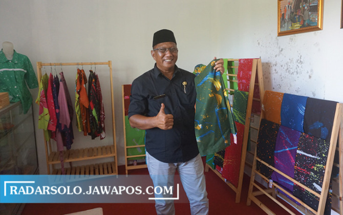 BERDAYAKAN WARGA: Kades Kemudo Hermawan Kristanto tunjukan batik ciprat karya penyandang disabilitas di showroom Kantor Desa Kemudo. (ANGGA PURENDA/RADAR SOLO)