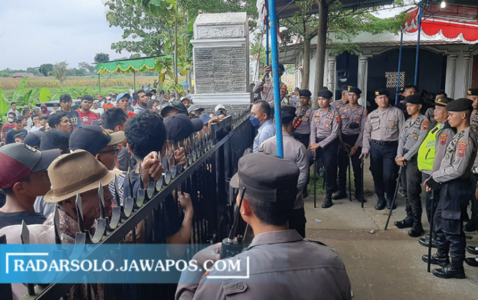 JADI ATENSI: Massa pendukung cakades Desa Manggis, Kecamatan Mojosongo, dijaga ketat personel Polres Boyolali, kemarin (7/12). Sempat terjadi ketegangan, namun berhasil diredam. (RAGIL LISTIYO/RADAR SOLO)