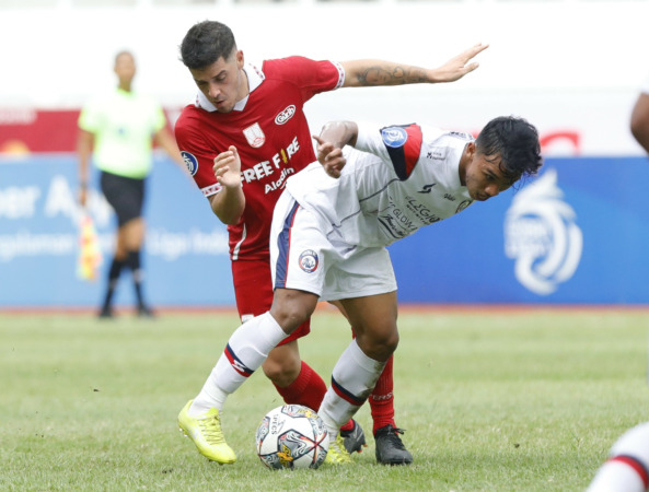 BERJIBAKU: Gelandang Persis Solo Alexis Messidoro berebut bola dengan pemain Arema FC Arkhan Fikri di Stadion Jatidiri, Minggu (11/12). (ANGGER BONDAN/JAWA POS)