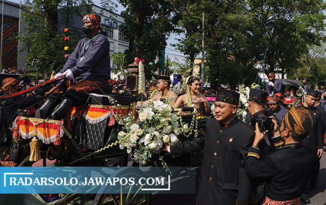 MOMEN LANGKA: Warsito menarik kuda yang dinaiki Kaesang-Erina dalam kirab di Jalan Slamet Riyadi kemarin (11/12). (M. IHSAN/RADAR SOLO)