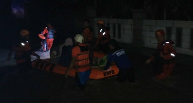 Petugas mengevakuasi warga Dusun Songgorunggi, Desa Dagen, Kecamatan Jaten yang terdampak banjir, Jumat malam (23/12/2022). (RUDI HARTONO/RADAR SOLO)