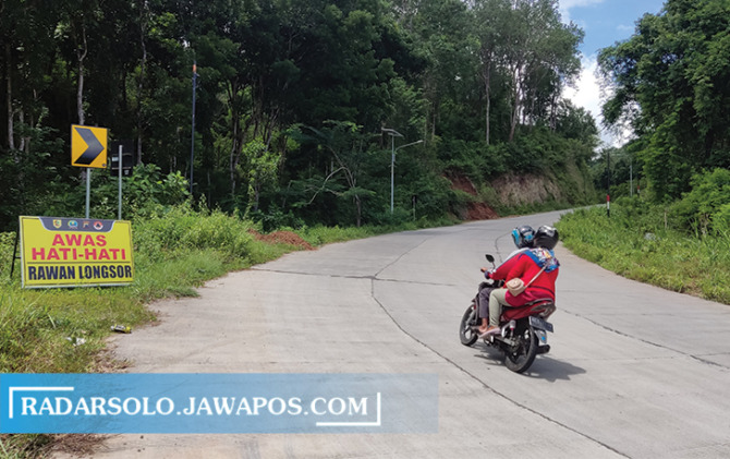 ALTERNATIF: Rambu peringatan rawan longsor di jalur lingkar kota (JLK) Wonogiri Kota. Pemudik diimbau berhati-hati saat hujan deras. (IWAN ADI LUHUNG/RADAR SOLO)