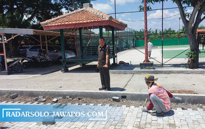 PASTIKAN KUALITAS: Ketua DPRD Sragen Suparno mengecek penataan paving di aula serbaguna DPRD, Selasa (20/12). (AHMAD KHAIRUDIN/RADAR SOLO)