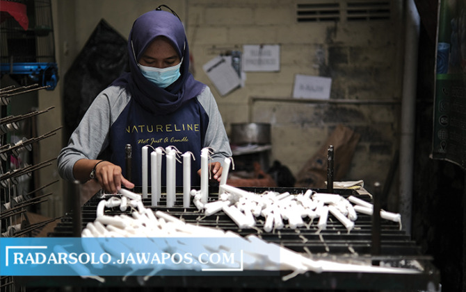 BERGELIAT: Pekerja tengah menata lilin yang sudah dibuat. (ARIEF BUDIMAN/RADAR SOLO)