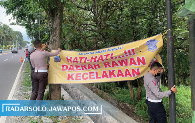TITIK RAWAN: Pemasangan banner imbauan di Jalan Raya Solo-Semarang, Desa Penggung, Boyolali Kota. Selain itu, pemasangan juga dilakukan di jalur tol. (RAGIL LISTIYO/RADAR SOLO)